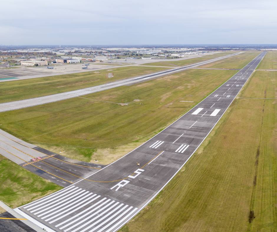 An aerial view of an airport runway with a large amount of pavement markings.