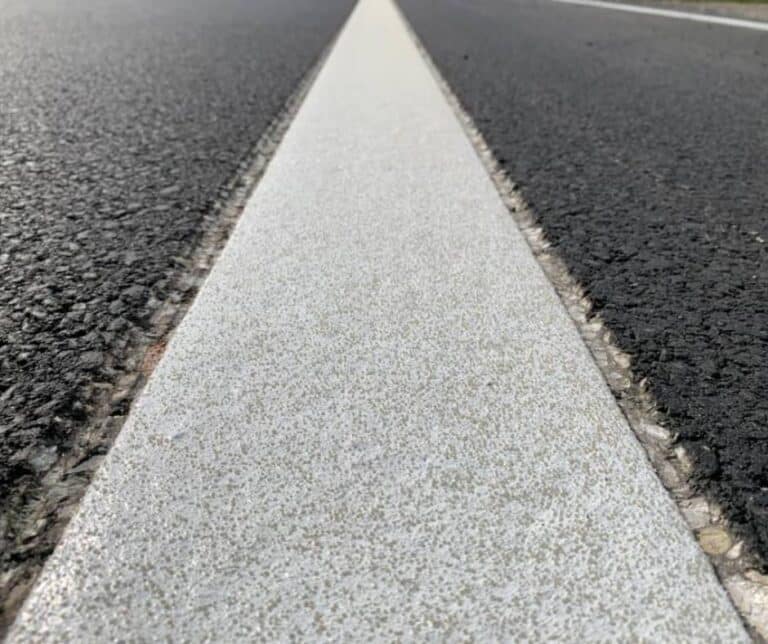 White recessed wet reflective marking on a highway.